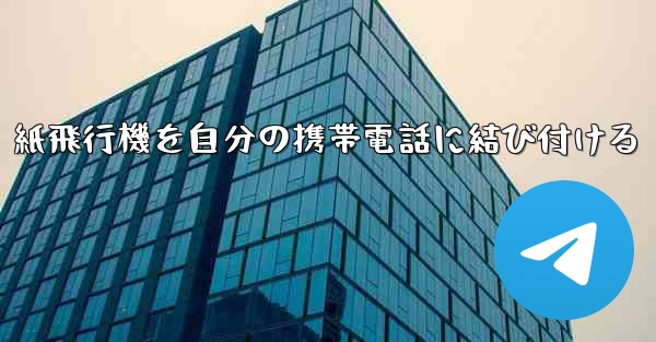 紙飛行機を自分の携帯電話に結び付ける